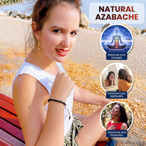 A woman sits on a bench by the waterfront, wearing a Genuine Azabache Bracelet with an adjustable black rope, renowned for its spiritual protection. Three circular insets highlight its benefits: balancing energies, enhancing spirituality, and offering good luck. Autumn leaves create a vibrant tapestry on the ground around her.